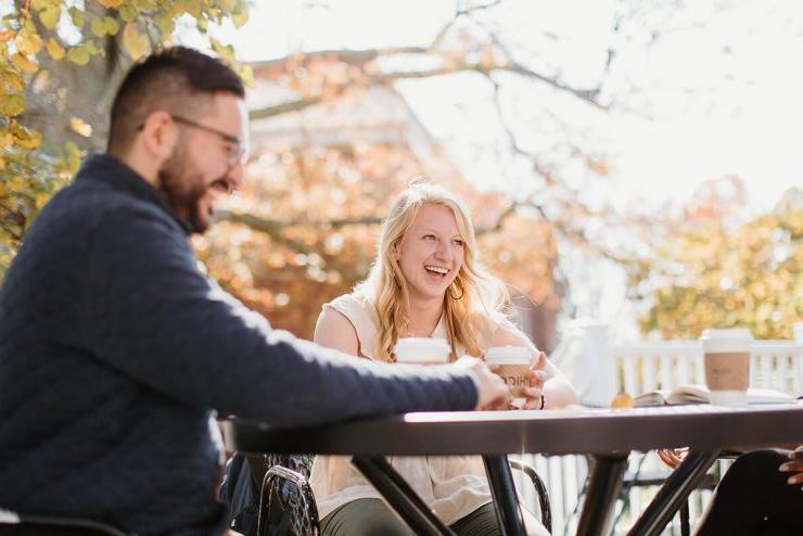 立博体育登录(艾斯拜瑞大学市)的三名学生，其中两名可以看到，围坐在户外的一张桌子旁喝咖啡
